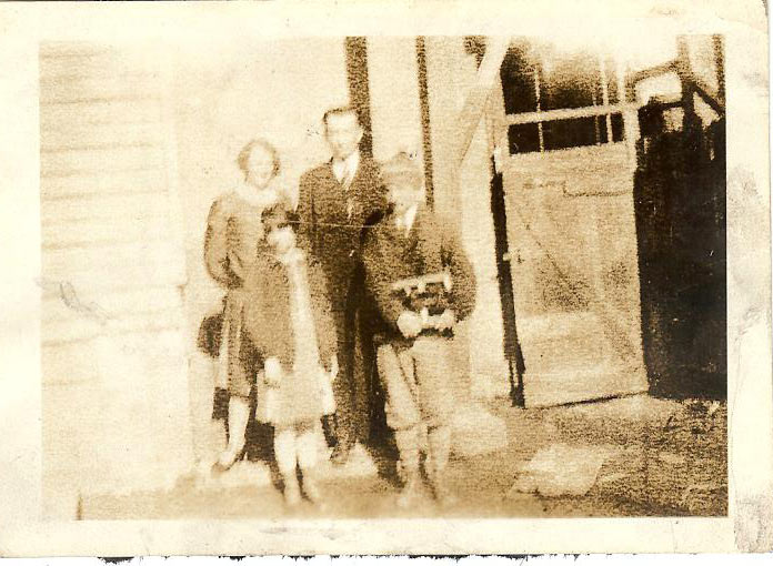 Photo of Ed with his ice skates, 1920's, with family.